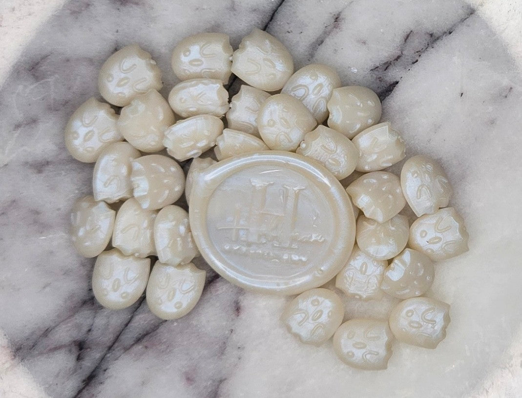 shimmering pearlescent wax seal bead that dances with iridescent auras of color, like light on a disco ball.