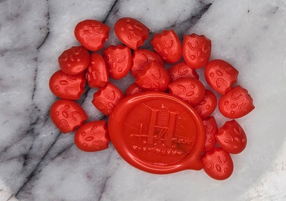 a bold, vibrant red wax seal bead that captures the playful charm and striking elegance of its namesake