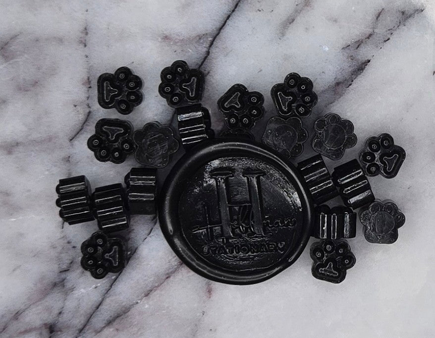 rich, glossy black wax seal bead with a hint of sweetness and bold sophistication, reminiscent of the classic candy