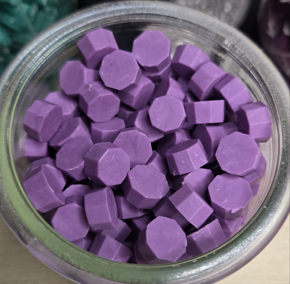 a smooth, muted purple wax seal bead with a velvety finish that evokes quiet elegance and moody sophistication